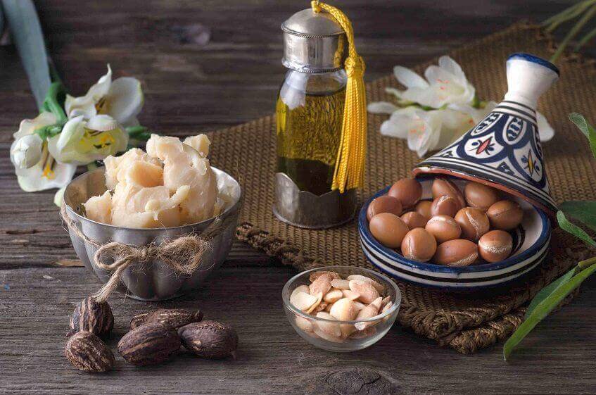 Arranged Moroccan argan oil, nuts, and ingredients on a rustic backdrop, showcasing natural beauty products.