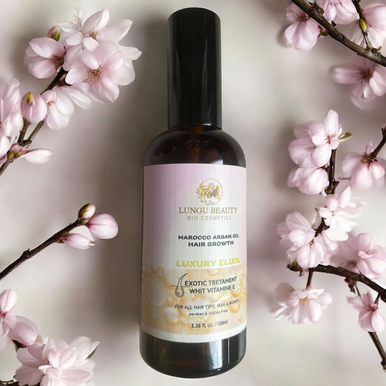 Argan oil hair treatments in a luxury elixir bottle with cherry blossom accents.
