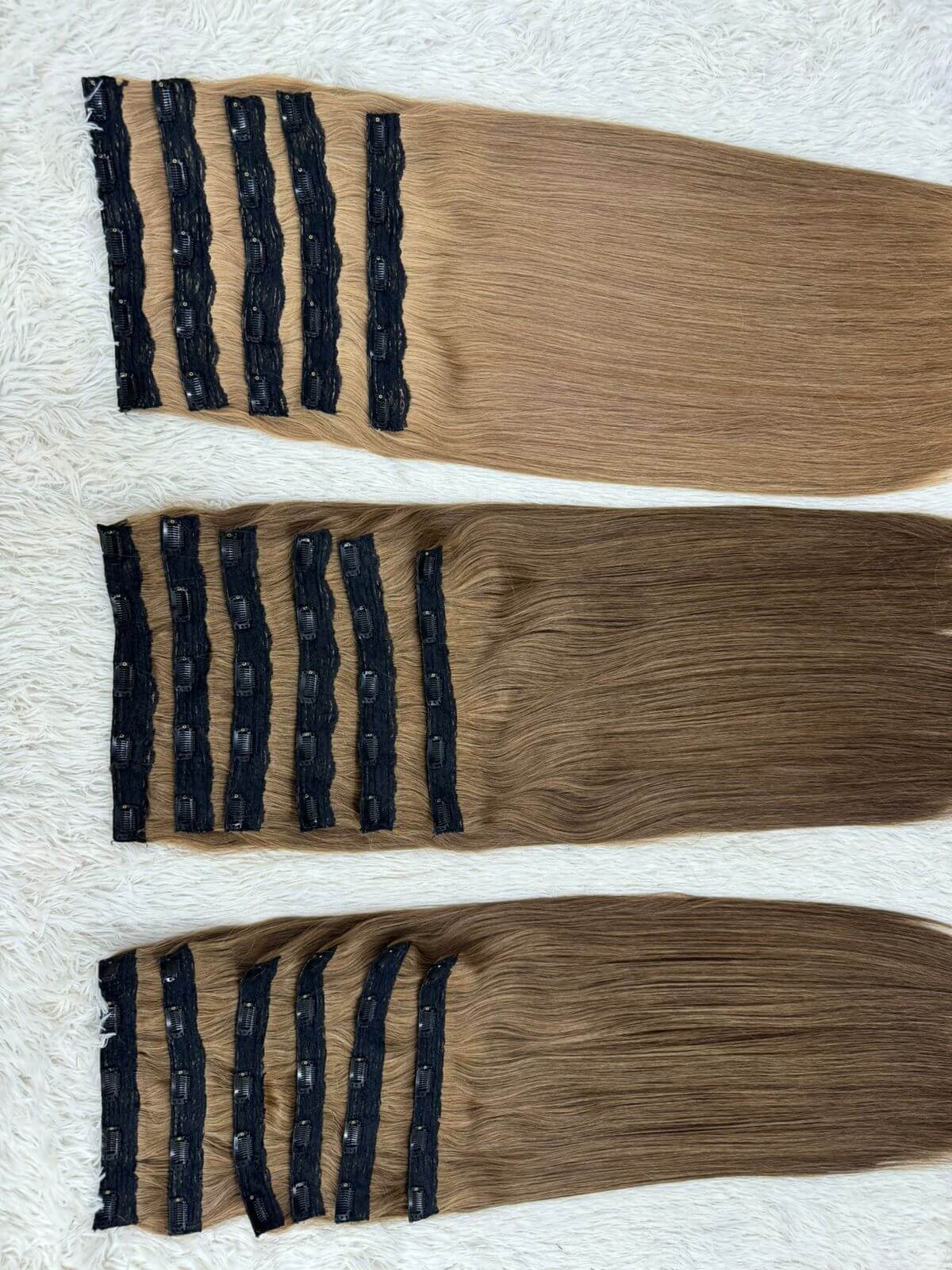 Clip-In & Ponytail Hair Extensions displayed on a white background showcasing different shades and clip details.