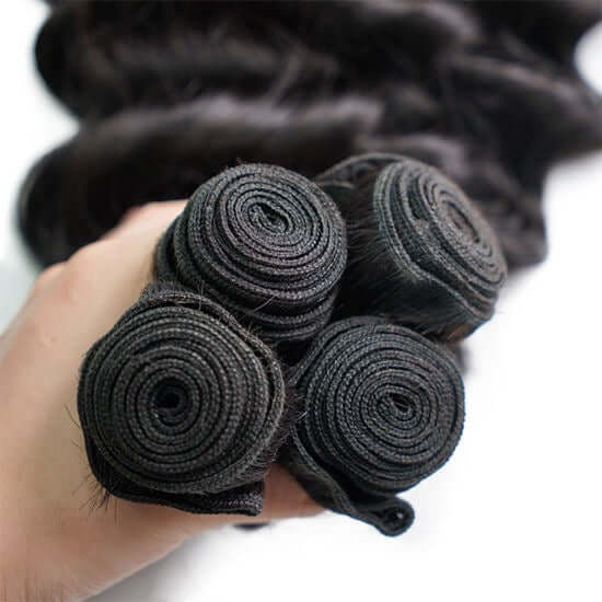 Natural Curly Hair – Machine-Wefted Bundles (10”–32”) in All Colors - close-up of wefted bundles in hand.
